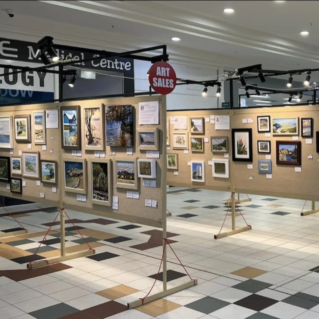 Framed landscape paintings displayed for sale in a shopping centre